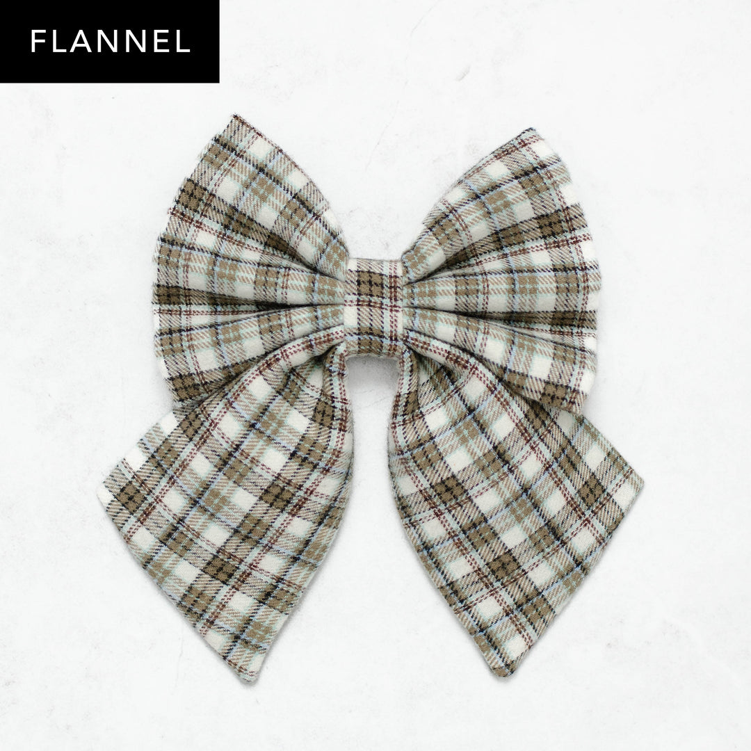Plaid bow on a white background with 'Flannel' text above.